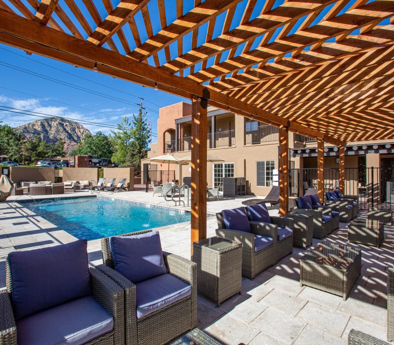 Outdoor sitting area by the swimming pool at Arroyo Pinion Boutique Hotel in Sedona with stunning red rock views