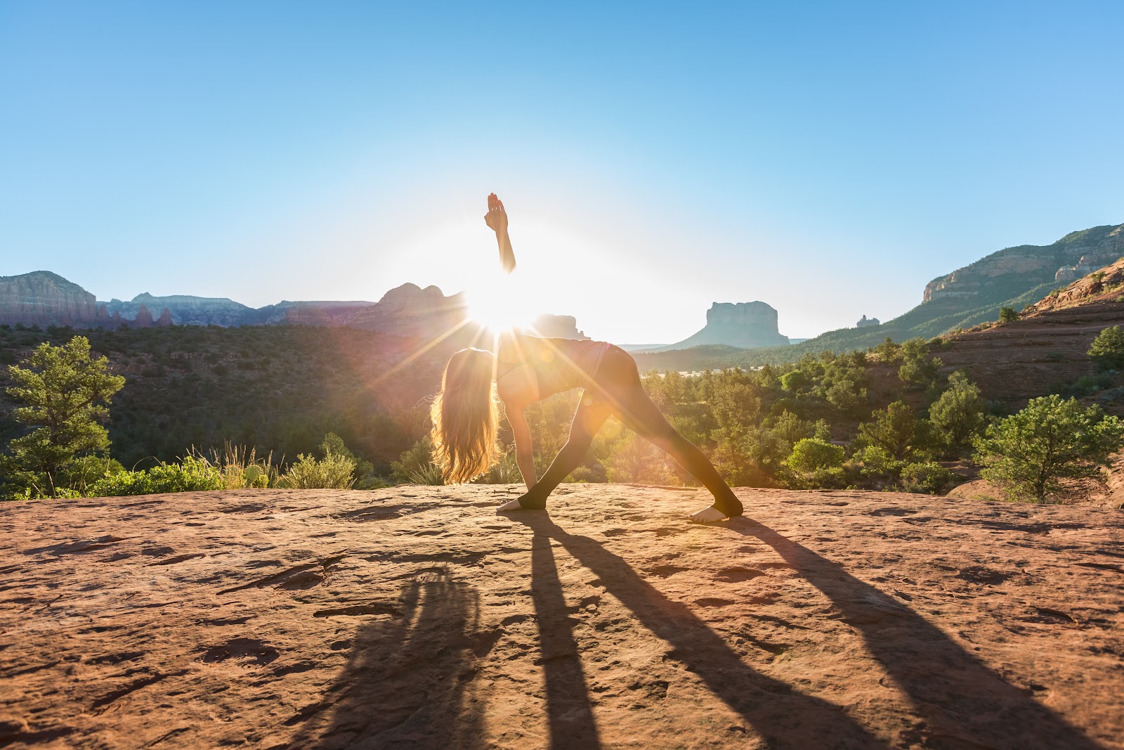 Sunrise yoga pose overlooking Sedona's red rocks