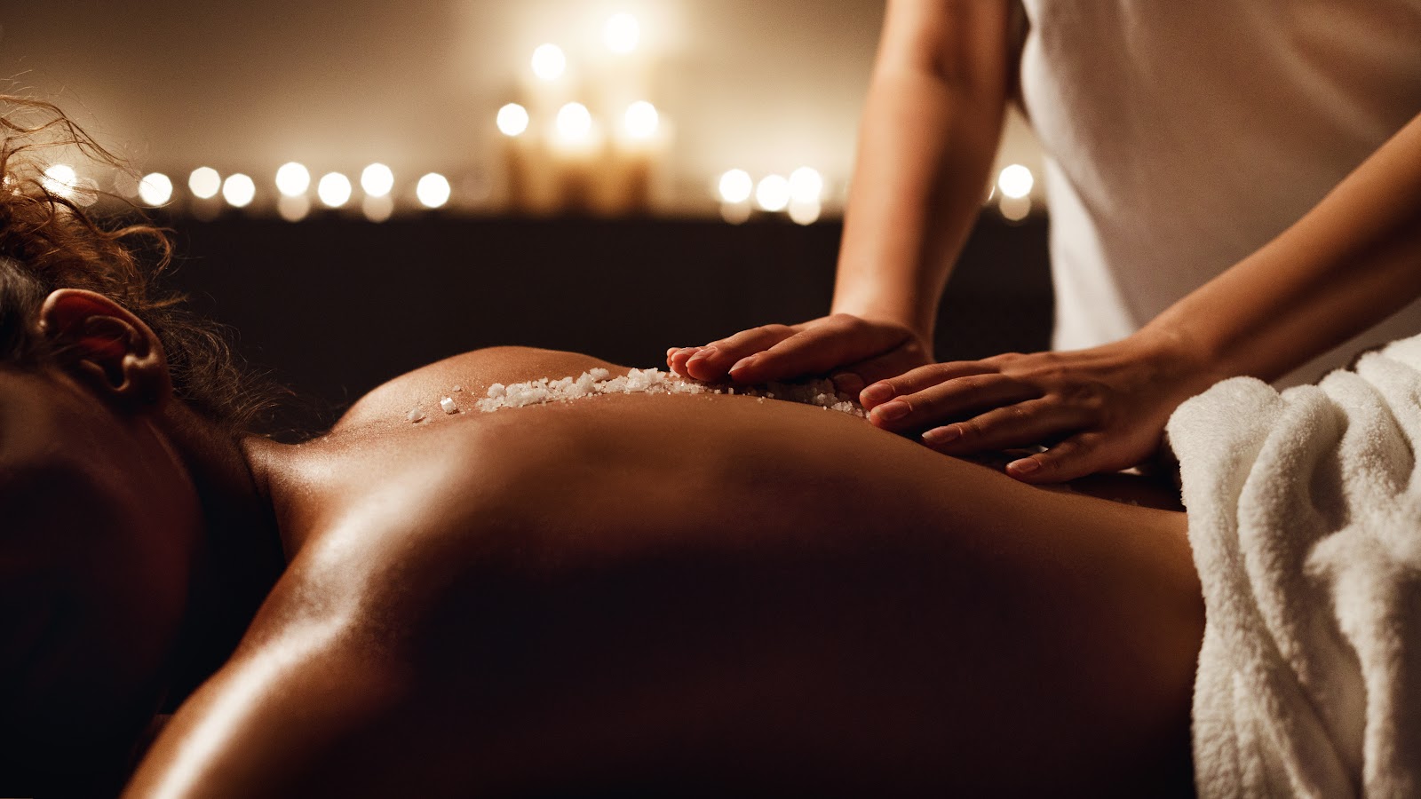 Massage therapist working a guest’s shoulders and upper back during a spa treatment