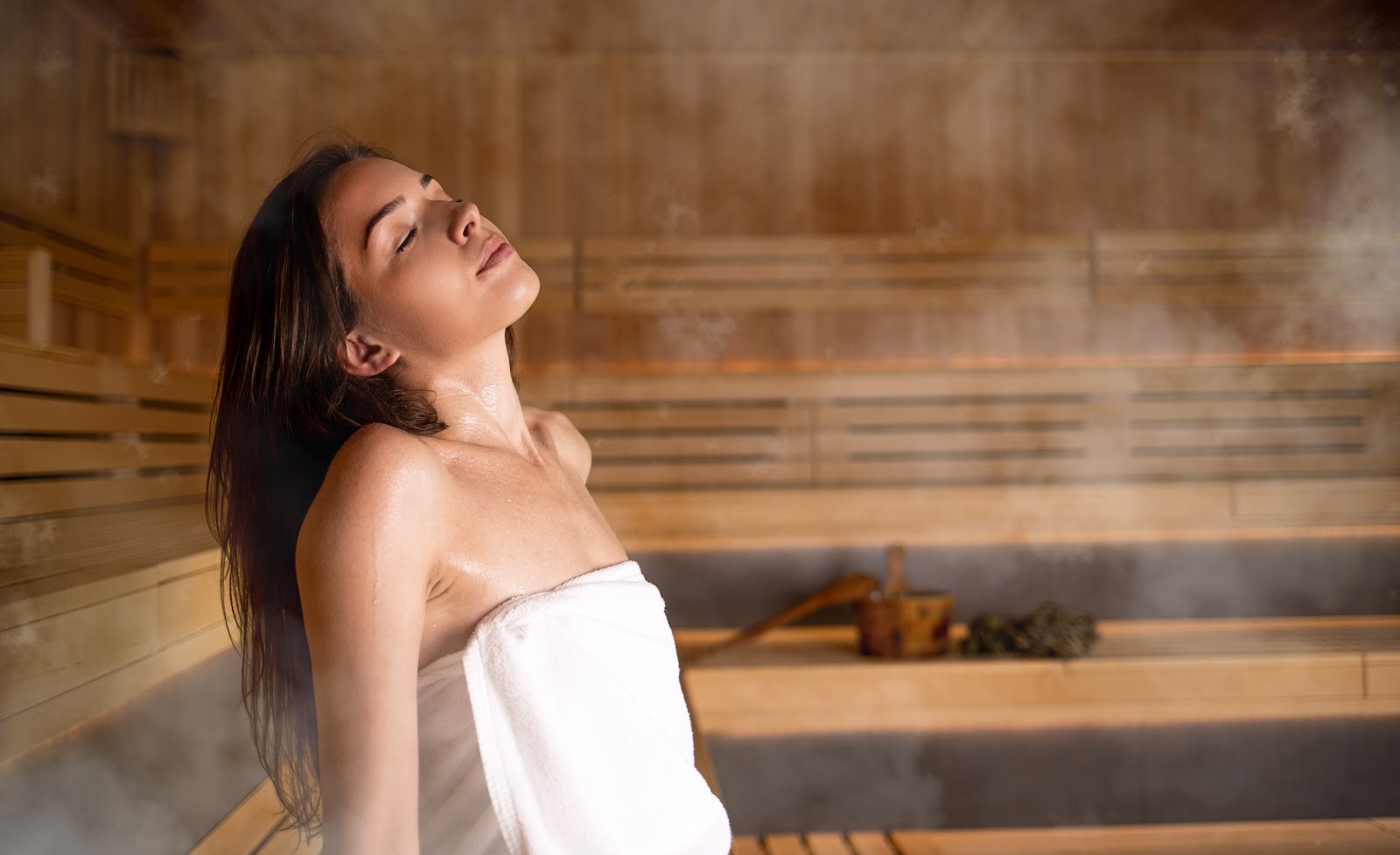 Guest relaxing in a warm wood-panelled sauna used for heat and contrast therapy