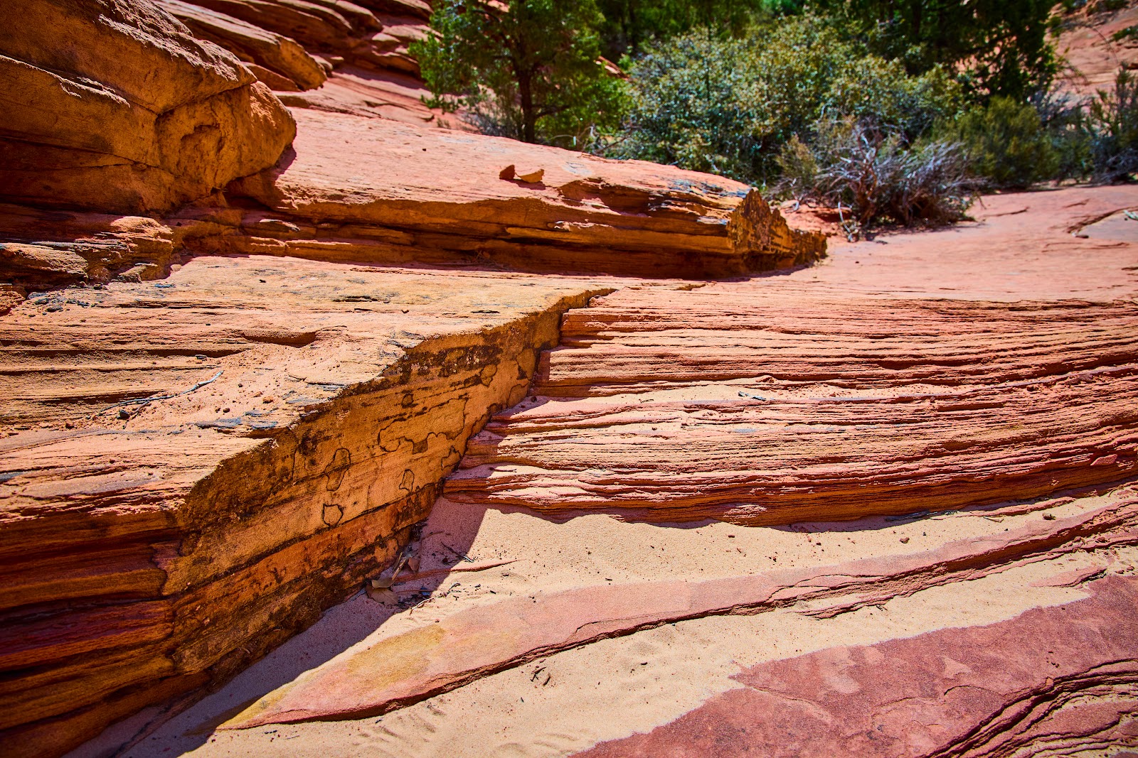Close-up of layered red and orange sandstone strata showing the iron-oxide banding that makes Sedona’s rocks red