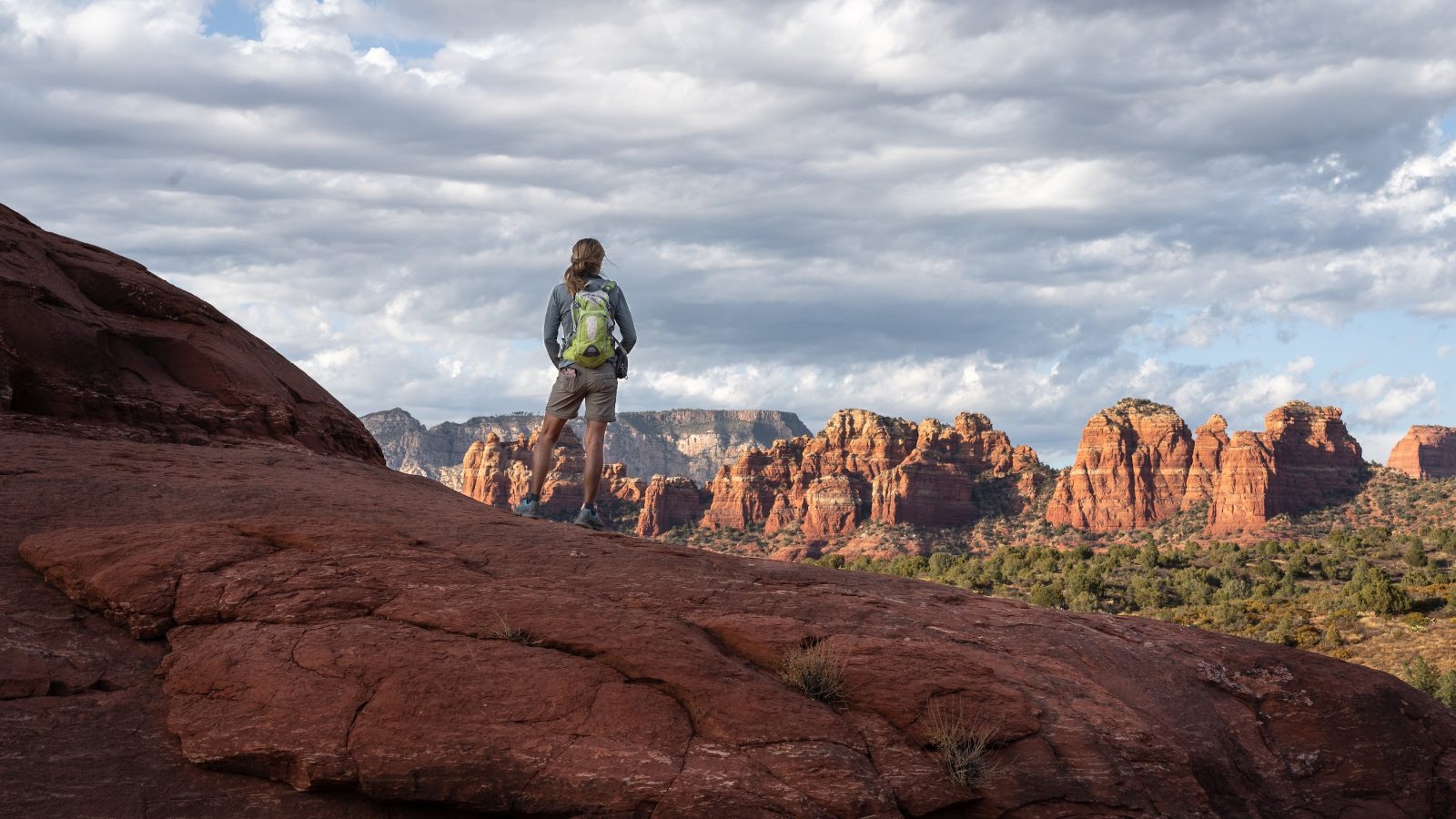 Hiker on a red rock overlook in Sedona, Arizona, a classic view on a Sedona vortex hike