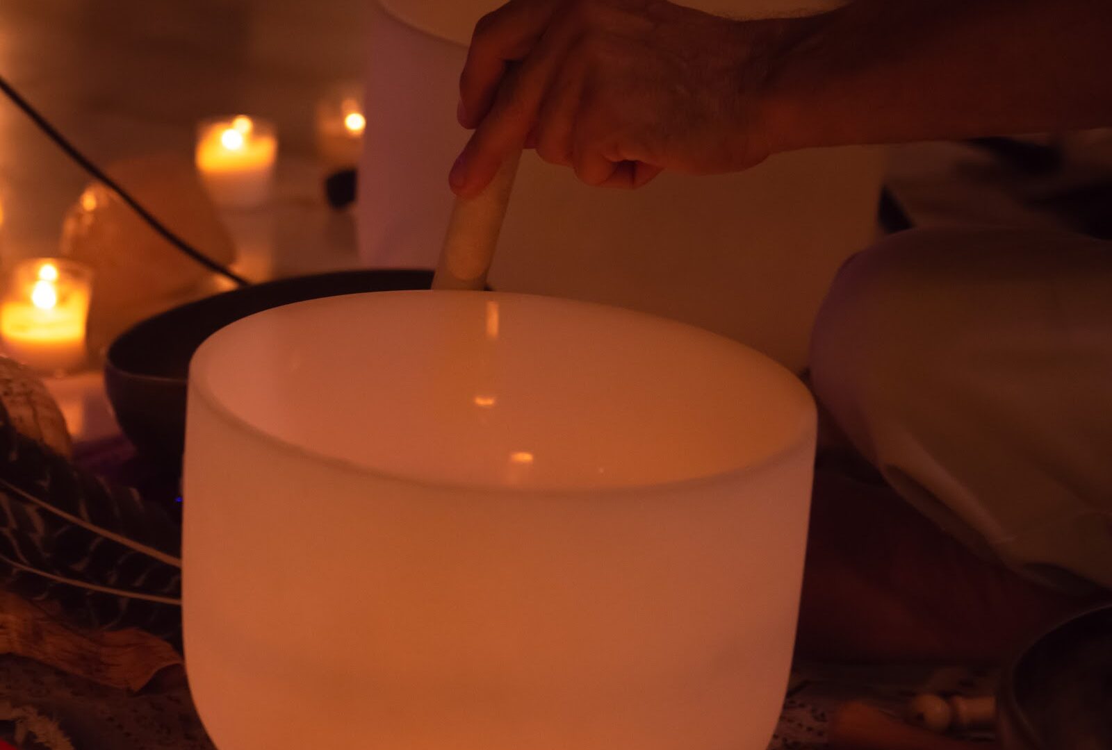 Crystal singing bowl beside candles, set up for a Sedona sound bath
