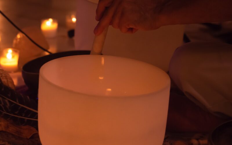 Crystal singing bowl beside candles, set up for a Sedona sound bath