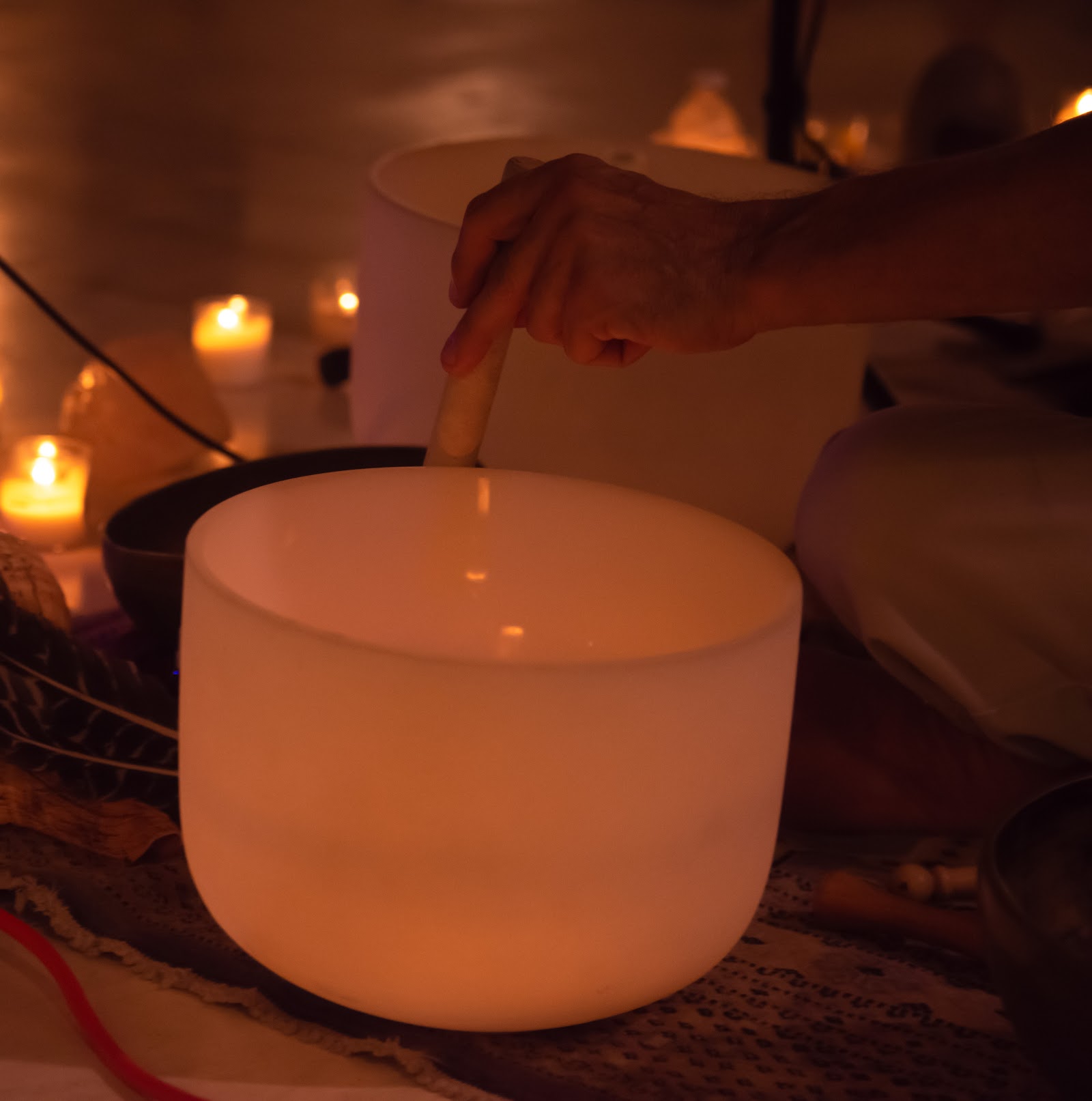Crystal singing bowl beside candles, set up for a Sedona sound bath